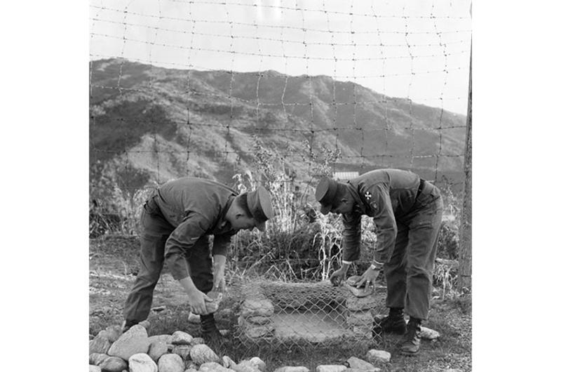 Hilltop home of PFC Teddy Arnold (left) and SP/5 John Copas gets an added touch - a barbecue pit. It's somewhat out of season now, but summer isn't too far off.
