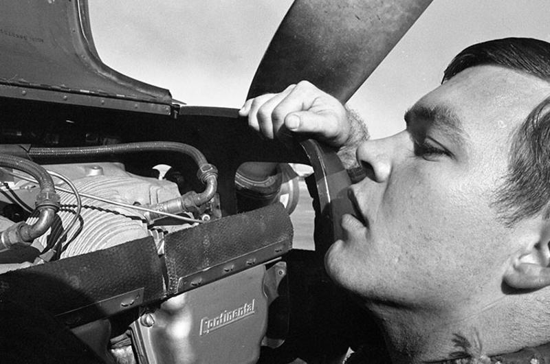 An unidentified member of the 220th "Catkillers" Aviation Company checks the engine of one of the company's airplanes.