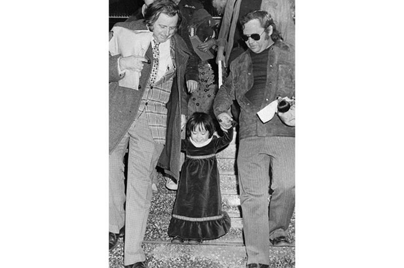 A beaming Kim Yon Jin - now Jenny Jones - is led down a stairway at Tokyo International Airport Tuesday by Pacific Stars and Stripes Hal Drake (left) and Jim Lea.