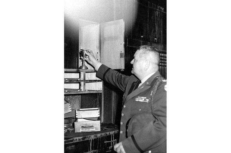 Col. Alphonse J. V. Fiedorczyk, deputy 8th Army chaplain, examines a charred chapel cabinet from which he salvaged chalices which were unharmed by the flames.