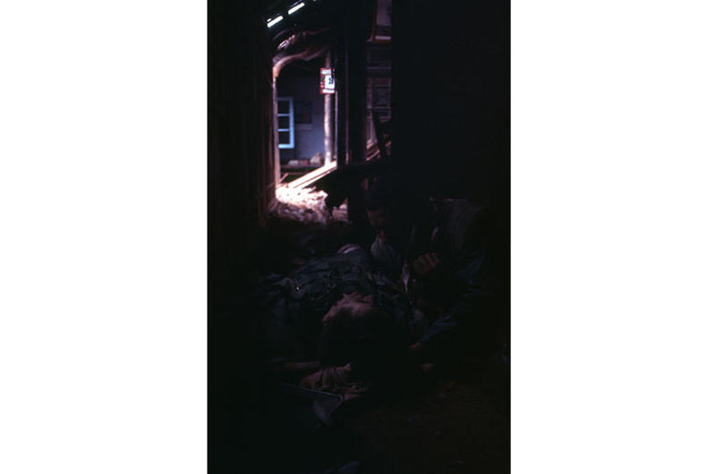 Wounded Marine, lies bleeding in a vacant villa as a fellow Marine, also wounded, tries to tend to his wounds.
