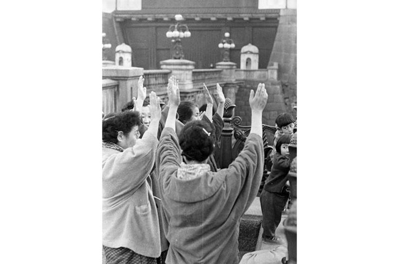 A group of rejoicing women offer "Banzais" in front of the Imperial Palace