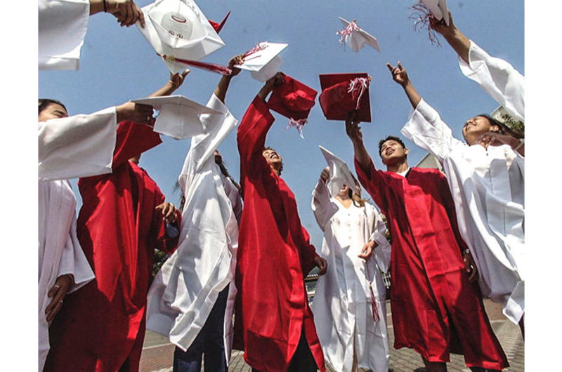 Graduating seniors from Nile C. Kinnick High School toss their caps into the air as they mark the beginning of a new phase of their lives.