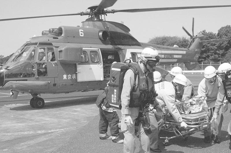 Tokyo Fire Department personnel carry a simulated patient out of a TFD helicopter during a training drill Wednesday at the Hardy Barracks heliport.