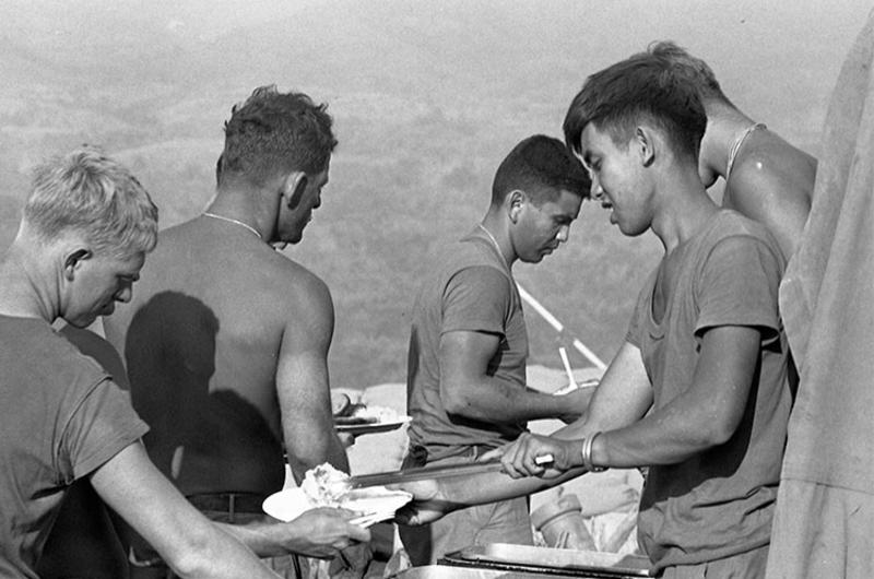 The men from Company A, 3rd Battalion, 12th Infantry Division and 6th Battalion, 29th Artillery Division stand in the chow line for a hot meal at Fire Support Base 25.