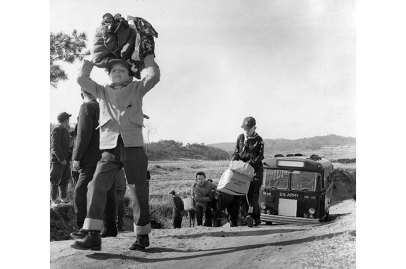 CHARITY "SAFARI" - American cub scouts, their bus forced to stop because of the narrow, steep road, step off on a quarter-mile trek to deliver clothing to the Pubwon Orphange.