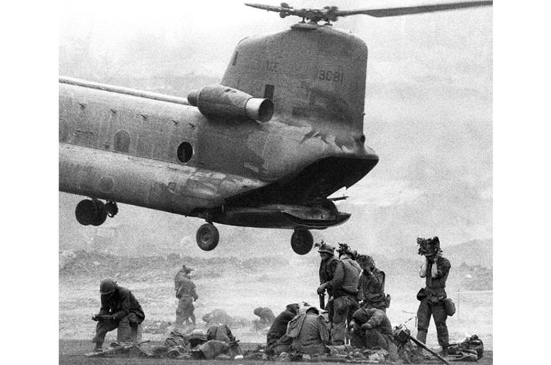 A CH-47 Chinook helicopter looms over soldiers preparing for action during Operation Pegasus, a 20,000-man effort to relieve Marines at the beleaguered combat base at Khe Sanh.