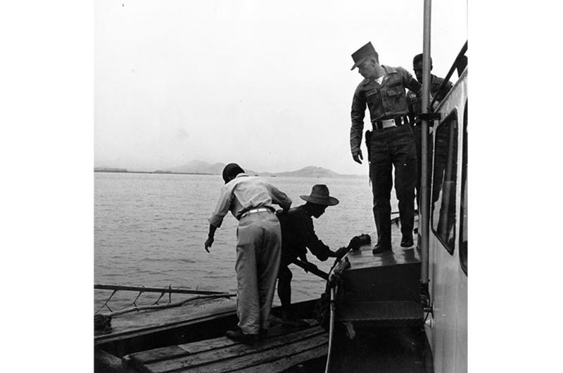 Patrol boat comes alongside small Korean boat in Inchon harbor and warns boatman to move his craft away from the ship unloading area.