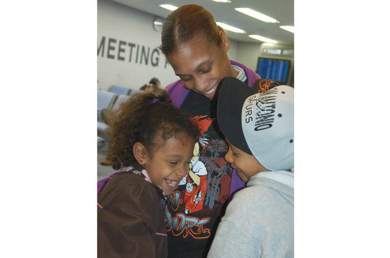 A mother hugs her children.