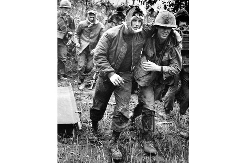 Injured gunship crewmen are helped to a Medevac copter during a three-day operation by B Company, 2nd Battalion, 12th Cavalry in the Que Son Valley, 35 miles from Da Nang.