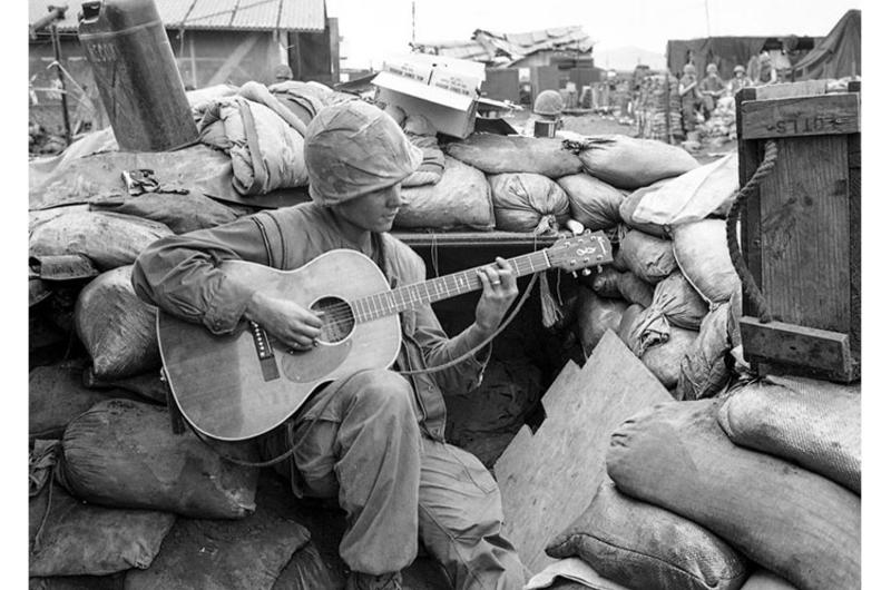 A Marine finds some time to play his guitar amid the sandbags of a dugout at the Khe Sanh base.
