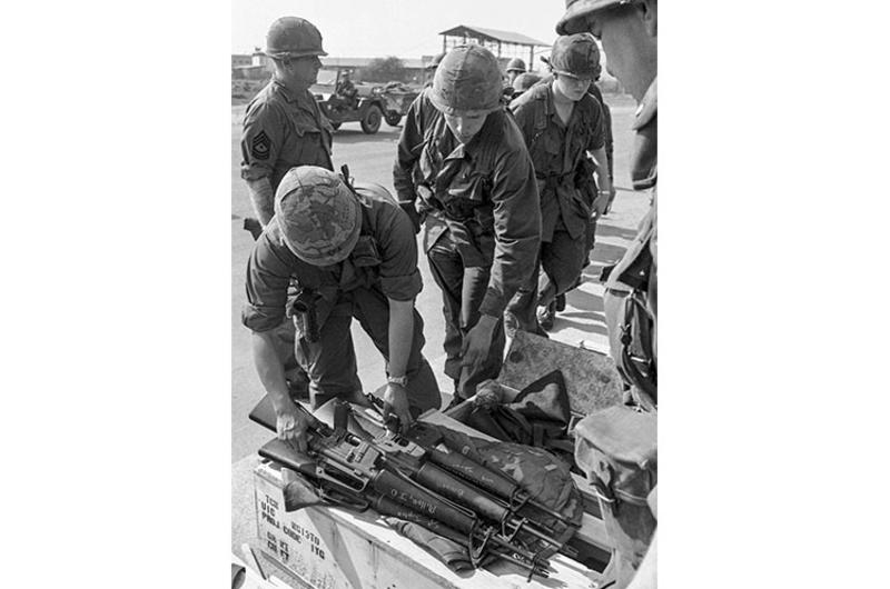 Newly-arrived troops of 6th Battalion, 31st Infantry, 9th Infantry Division pick up their rifles from crates on the airport tarmac.