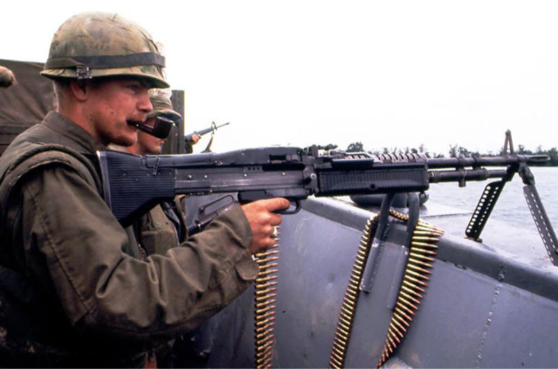 A machine gunner keeps a close eye out for enemy activity on the shoreline as U.S. Marines cross the Perfume River for an assault on the ancient imperial capital of Hue during the Tet Offensive.