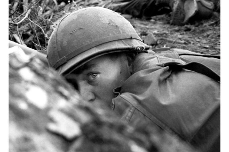American soldiers take cover from enemy fire during a three-day operation by B Company, 2nd Battalion, 12th Cavalry in the Que Son Valley, 35 miles from Da Nang.