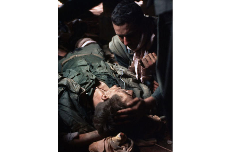 A wounded Marine sheltered in a vacant villa is tended to by a medic during the Tet Offensive battle for the former imperial capital city.