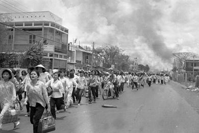 Refugees flee burning buildings near Tan Son Nhut. Viet Cong and North Vietnamese forces started shelling more than 120 provincial capitals, towns and allied military installations across South Vietnam  and battled governement and U.S. troops inside the capital Saigon, May 5th.