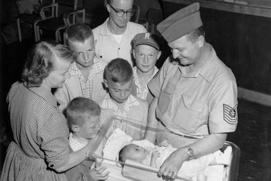 Admiring a new addition to their family - six-month-old Susan Marie Young - are Sgt. and Mrs. Young and their five sons.