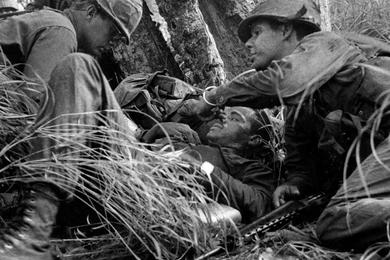 Squad leader Sgt. John Smith, is hit and patrol treats his wounds during fight.