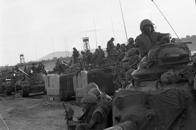 The 1st Battalion, 1st Regiment, 1st Marine Division moves to take up a position on the south side of Go Noi Island supported by Marine tanks and Landing Vehicles Tanks (LVTs).