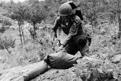 CHARGING A DUMMY representing the enemy during the intense testing, Sgt. Roger G. Cee of Salt Lake City, Utah, routs the "opponent" out of his foxhole. The sergeant tossed two grenades at the site before charging the make-believe enemy.