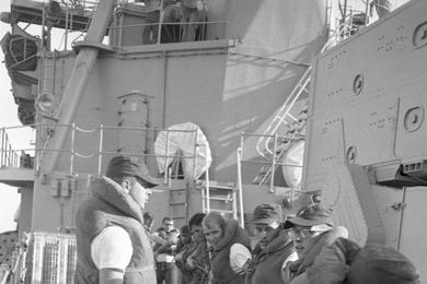 Sailors pull rope during the refueling and rearming operation on board the USS Buchanan destroyer by the tanker USS Tappahannock  [not visible].