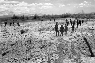 Members of the 2nd Battalion, 1st Regiment, 1st Marine Division move through a landscape marked by craters to take up a position on the north side of Go Noi Island.