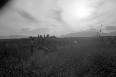 Marines prepare to go out on a sweep as the early morning sun tries to break through the clouds, having just risen above the mountains.