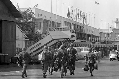 Fresh troops walk down the tarmac in Vietnam after having disembarked from the airplane. They are members of the 6th Battalion, 31st Infantry, 9th Infantry Division.
