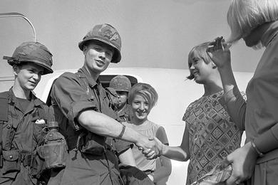 Fresh troops disembark from their airplane at an unindentified airport in Vietnam and are bid farewell by the pretty flight attendants of Braniff International airways on whose airplane they flew. They are members of the 6th Battalion, 31st Infantry, 9th Infantry Division.