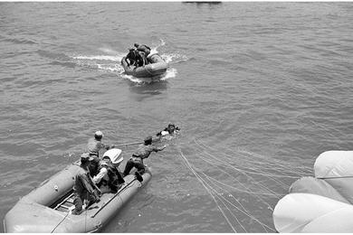 An Army of the Republic of Vietnam (ARVN) paratrooper is ready to get pulled aboard by Republic of Vietnam Navy after landing in Da Nang river.