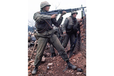 A U.S. Marine fires at the enemy over one of the outer walls surrounding the Hue Citadel during the infamous Tet Offensive.