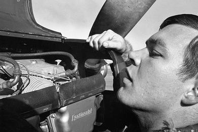 An unidentified member of the 220th "Catkillers" Aviation Company checks the engine of one of the company's airplanes.