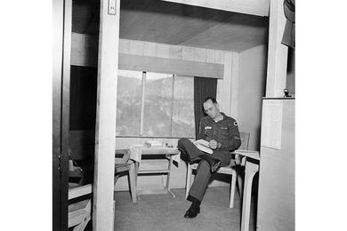 Enjoying home-like comfort in an extension he added to his regular Jamesway hut, located north of the 38th Parallel, M/Sgt. Clark M. Thaler of Hq., I Corps (Gp.) Arty., relaxes with a good book.