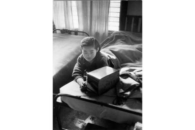 A Korean girl lays on her bed listening to the radio in one of the wards at the Seoul Children’s Relief Hospital.