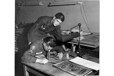 Former Marine Sgt. Steve Garniss, now an Army PFC with Hq. Co. of the U.S. Army 4th Missile Command in Korea, peers at an aerial photo map as SP4 John Pearce looks over his shoulder. 
