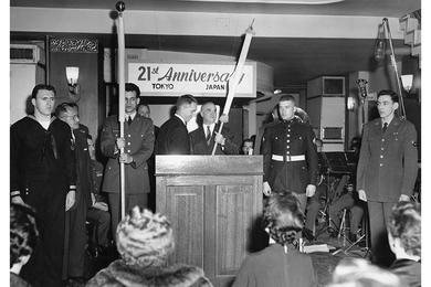 Flag Ceremony - U.S. Ambassador to Japan Edwin O. Reischauer (fourth from left) presents an American flag to Michael C. Sodano, chairman of the Tokyo USO Committee, during the USO's 21st anniversary celebration in Tokyo.