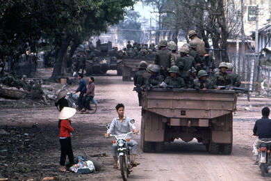 Vietnamese citizens populate the streets of Hue as a convoy of ARVN troops rumbles through.