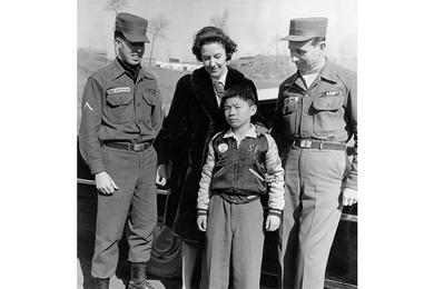 PFC MacLaughlin (left), Sgt. Huggins say goodby to Chul Soo Yu as Mrs. Mays takes him home.