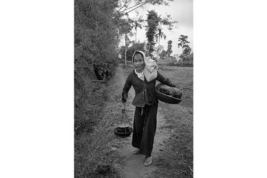 A local Vietnamese woman makes her way down a dirt path in Que Son Valley.