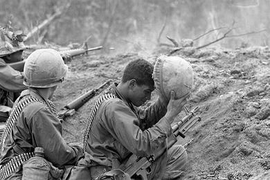 SP/4 Steve Johnson (Newark, NJ) adjusts his helmet as his assistant gunner SP/4 Ramon Aragon (Albuquerque, NM) watches radioman Duane Middleton (Tuckasegge, AL[NC?]) fire back at NVA fighters.