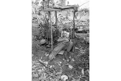 Unidentified cavalryman takes a rest under a wooden shelter.