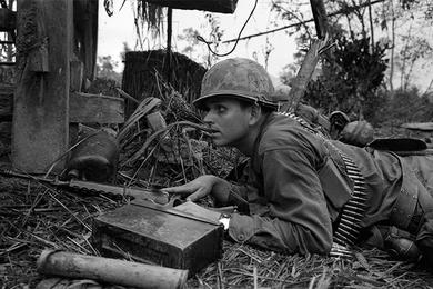 A cavalryman takes cover during a firefight in Que Son Valley