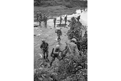 Cavalrymen of B Company, 2nd Battalion, 12th Cavalry Regiment cross a stream on patrol in Que Son Valley.