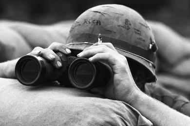 A U.S. Marine takes a closer look at North Vietnamese forces massed around the beleaguered base at Khe Sanh.