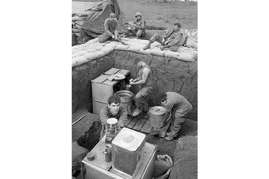 Marine cooks soup while others either sit around or work on improving kitchen facility at Khe Sanh.