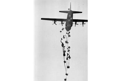 Supplies dropped out of an Air Force C-130 cargo plane pummel to the ground in the drop zone at Khe Sanh.
