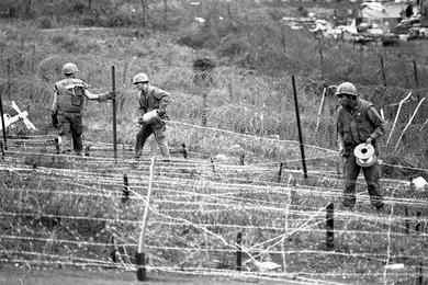 Marines lay down barbed wire on the perimeter of Khe Sanh Base.