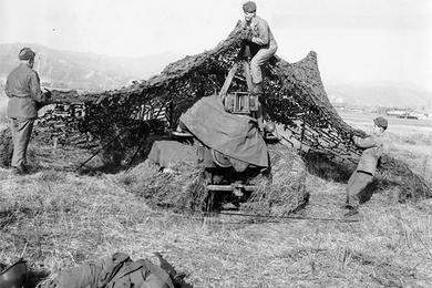 Engineers camouflage one of their bulldozers. All are riflemen, can quickly man perimeter for defense.