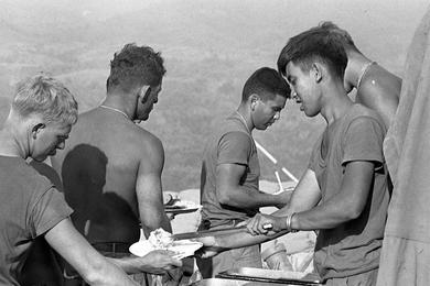 The men from Company A, 3rd Battalion, 12th Infantry Division and 6th Battalion, 29th Artillery Division stand in the chow line for a hot meal at Fire Support Base 25.