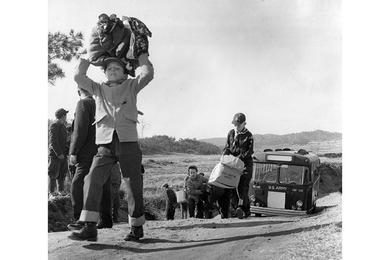 CHARITY "SAFARI" - American cub scouts, their bus forced to stop because of the narrow, steep road, step off on a quarter-mile trek to deliver clothing to the Pubwon Orphange.